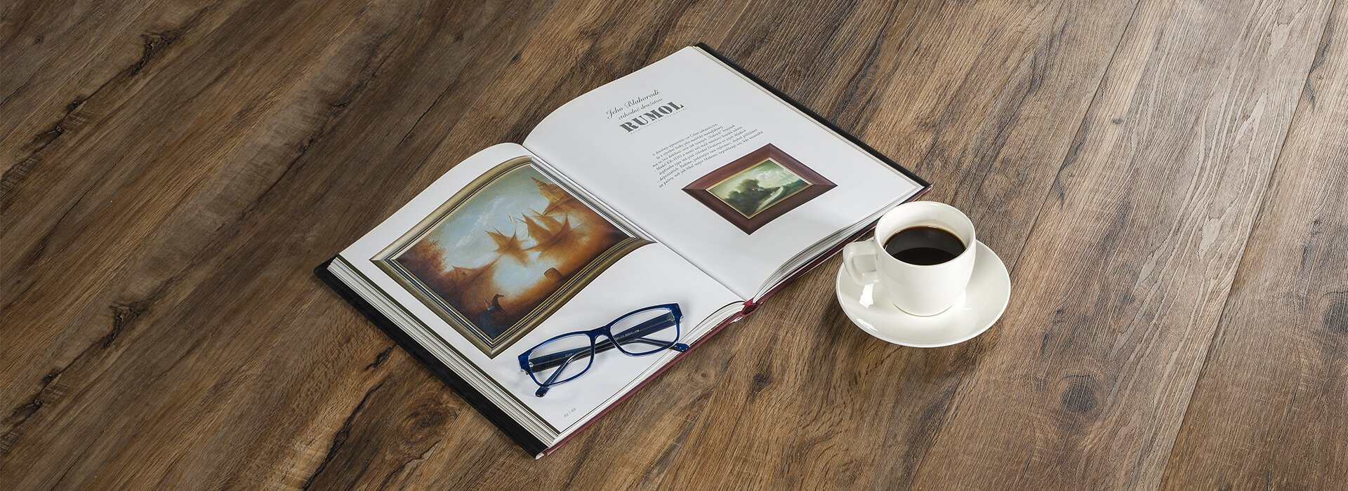 Kniha, káva a brýle ležící na podlaze